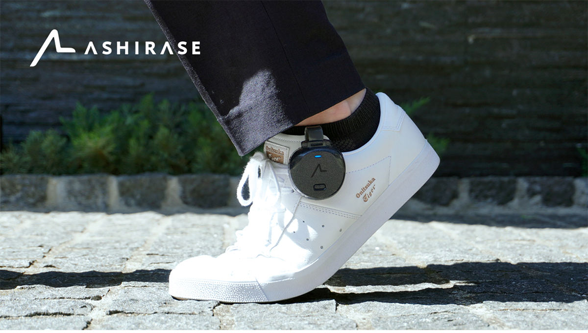 ASHIRASE device attached to a white sneaker