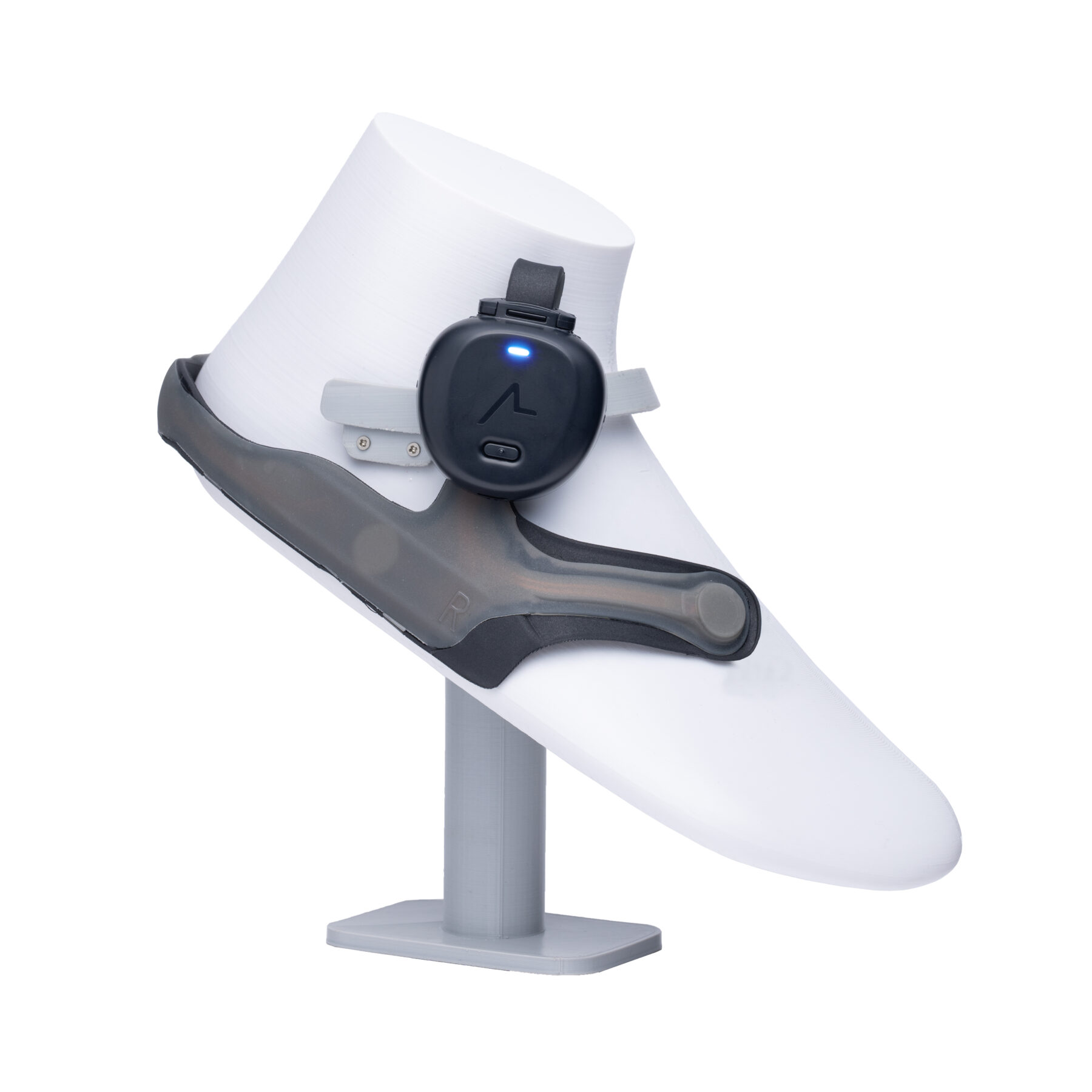 Close-up of the ASHIRASE navigation device mounted on a foot model, showing its wearable design for visually impaired users.